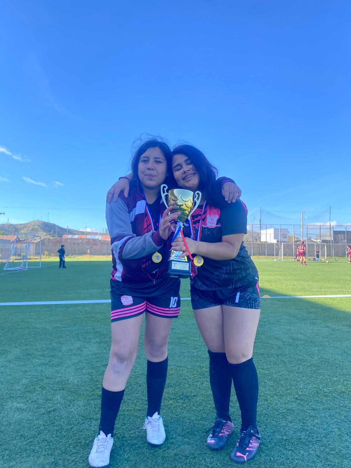 Dos jugadoras del CBO abrazadas con la copa y sus medallas